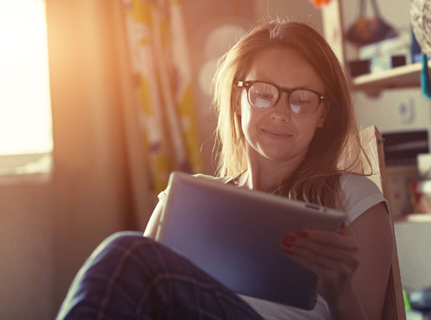 youthful person looking at tablet in morning sunlight