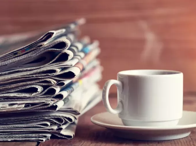 Coffee and a stack of newspapers.