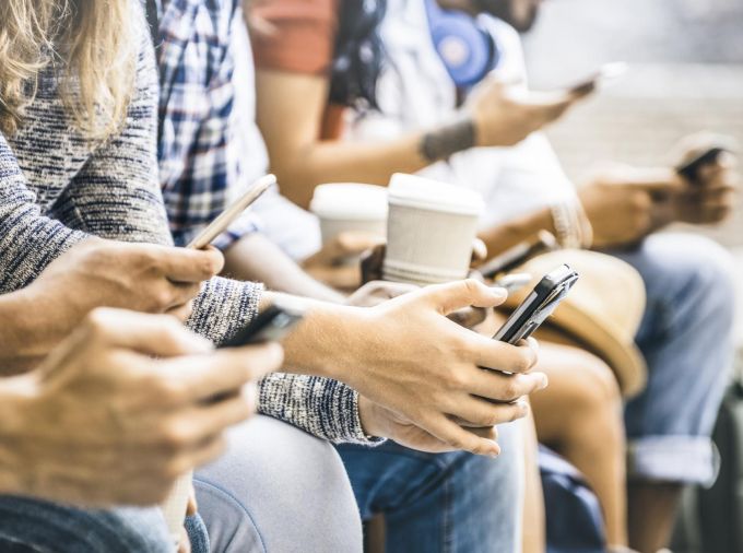 Hands holding phones and coffee