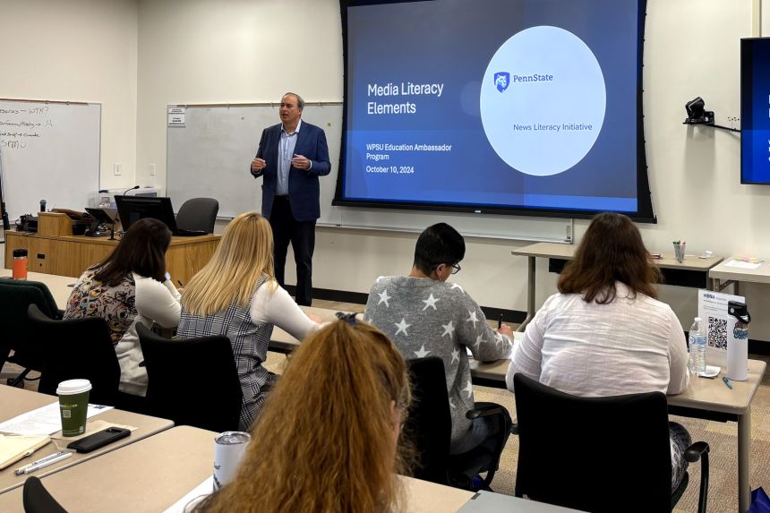 Professor and Director of the Penn State News Literacy Initiative, Matt Jordan stands at the front of a classroom of K12 educators before a projector screen with a slide that reads "Elements of Media Literacy."